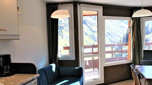 A cozy room with a sofa, a dining table, and a kitchen area with a coffee maker. - Sunny duplex for 6 in Avoriaz (Avoriaz)