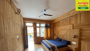 Una stanza in legno con un letto, una ventola a soffitto e una finestra.