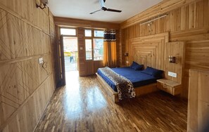 Quarto de madeira com cama, ventilador de teto e janela.