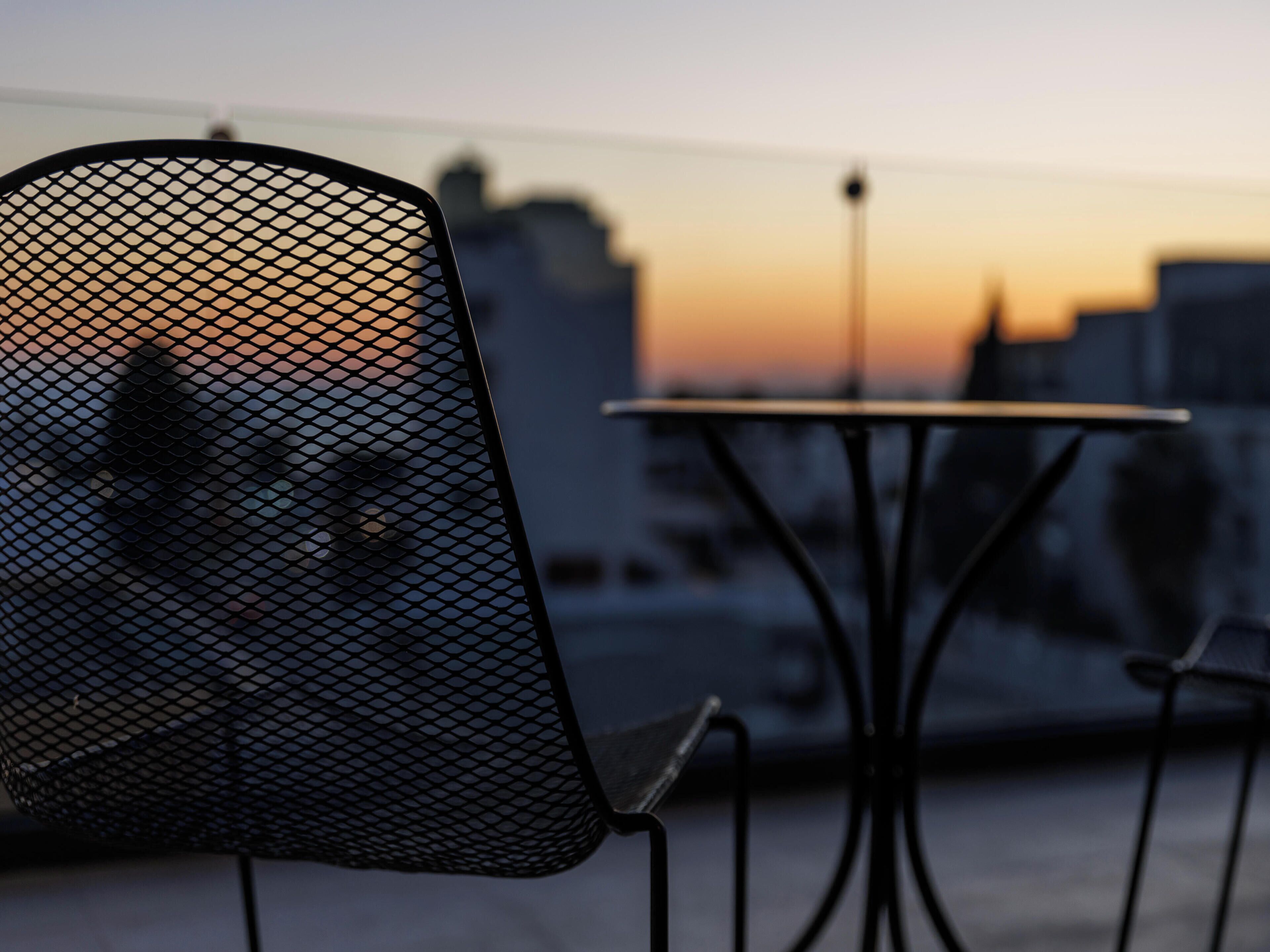 A chair with a mesh backrest and a table with a metal frame.