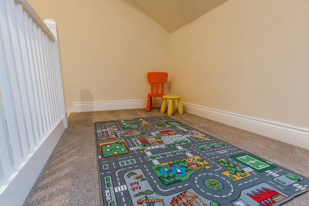A carpeted hallway with a play mat featuring a cityscape design.