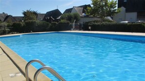A rectangular swimming pool with a metal ladder on the left side.
