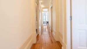 A hallway with wooden flooring and white walls. - Modern Comfy Flat by HostWise (Porto)