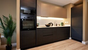 Una cucina moderna con forno integrato, lavello e piano di lavoro.
