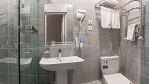 A modern bathroom with a glass-enclosed shower, a pedestal sink, and a toilet. - Tantana Hotel (Fergana)