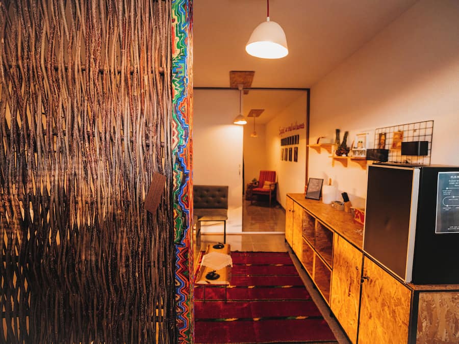 Una cocina moderna con armarios de madera, un refrigerador y una zona de comedor con alfombra roja.