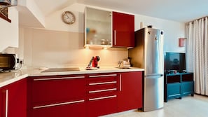 Une cuisine moderne équipée d’un four à micro-ondes, d’un réfrigérateur et d’une horloge murale.