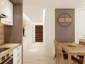 A modern kitchen with a built-in oven and a dining area with a wooden table and chairs. - Apartments Villa Subic (Rab)