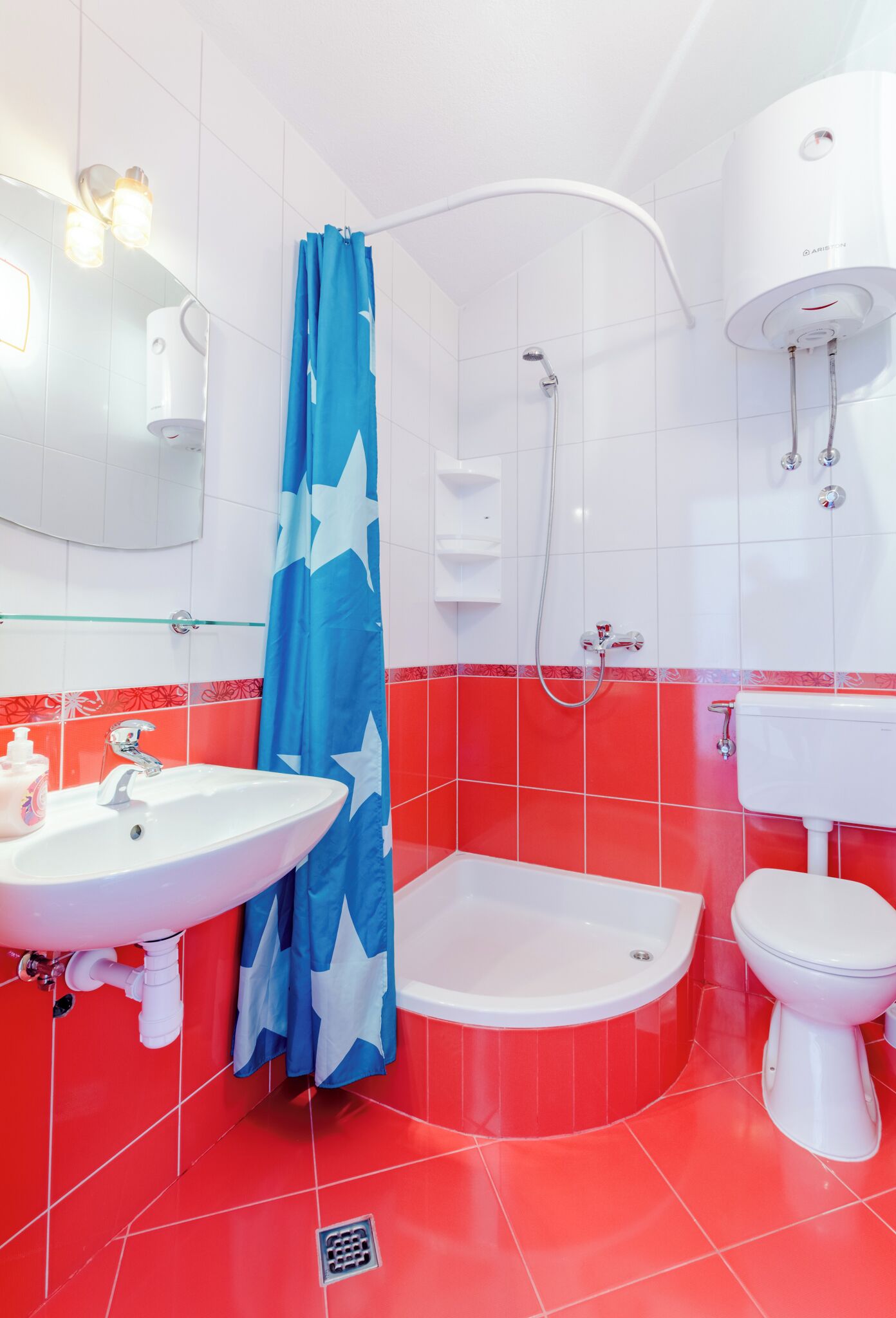 A bathroom with a white sink, toilet, and shower.