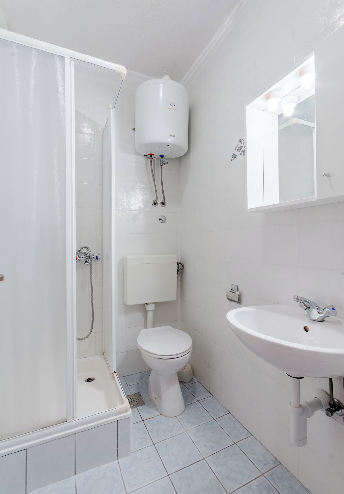 A bathroom with a shower, toilet, and sink.