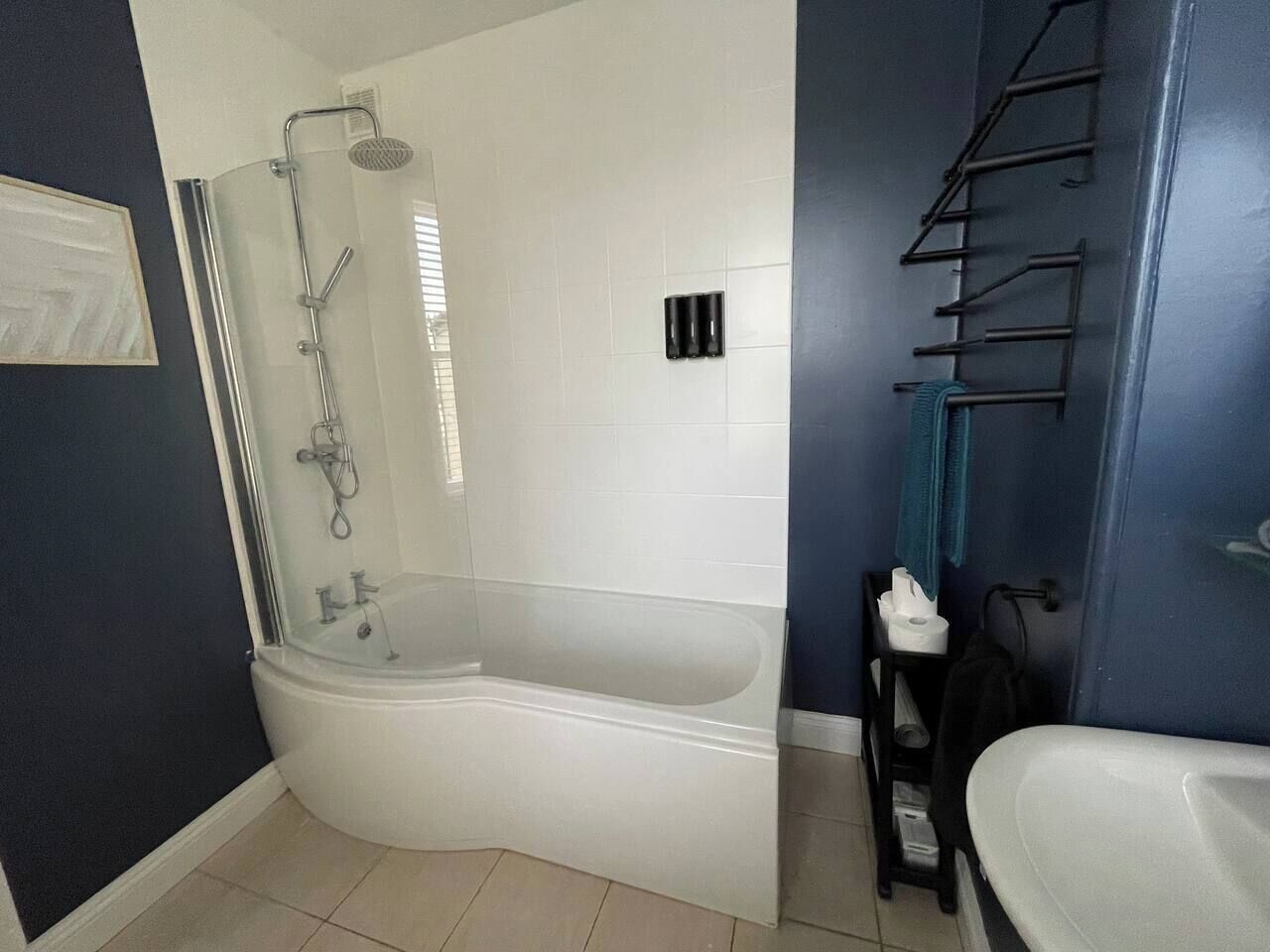 A bathroom with a glass-enclosed shower, a bathtub, and a toilet.