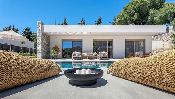 A modern house with a pool, stone walls, and outdoor seating. - Welcome to Emerald Estate, your serene retreat on Rhodes Island. (Rhodes)