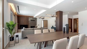 A modern dining area with a long table, chairs, and a sofa. - Welcome to Emerald Estate, your serene retreat on Rhodes Island. (Rhodes)