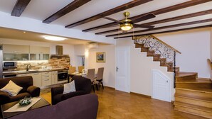 A spacious living area with a wooden staircase and a modern kitchen.
