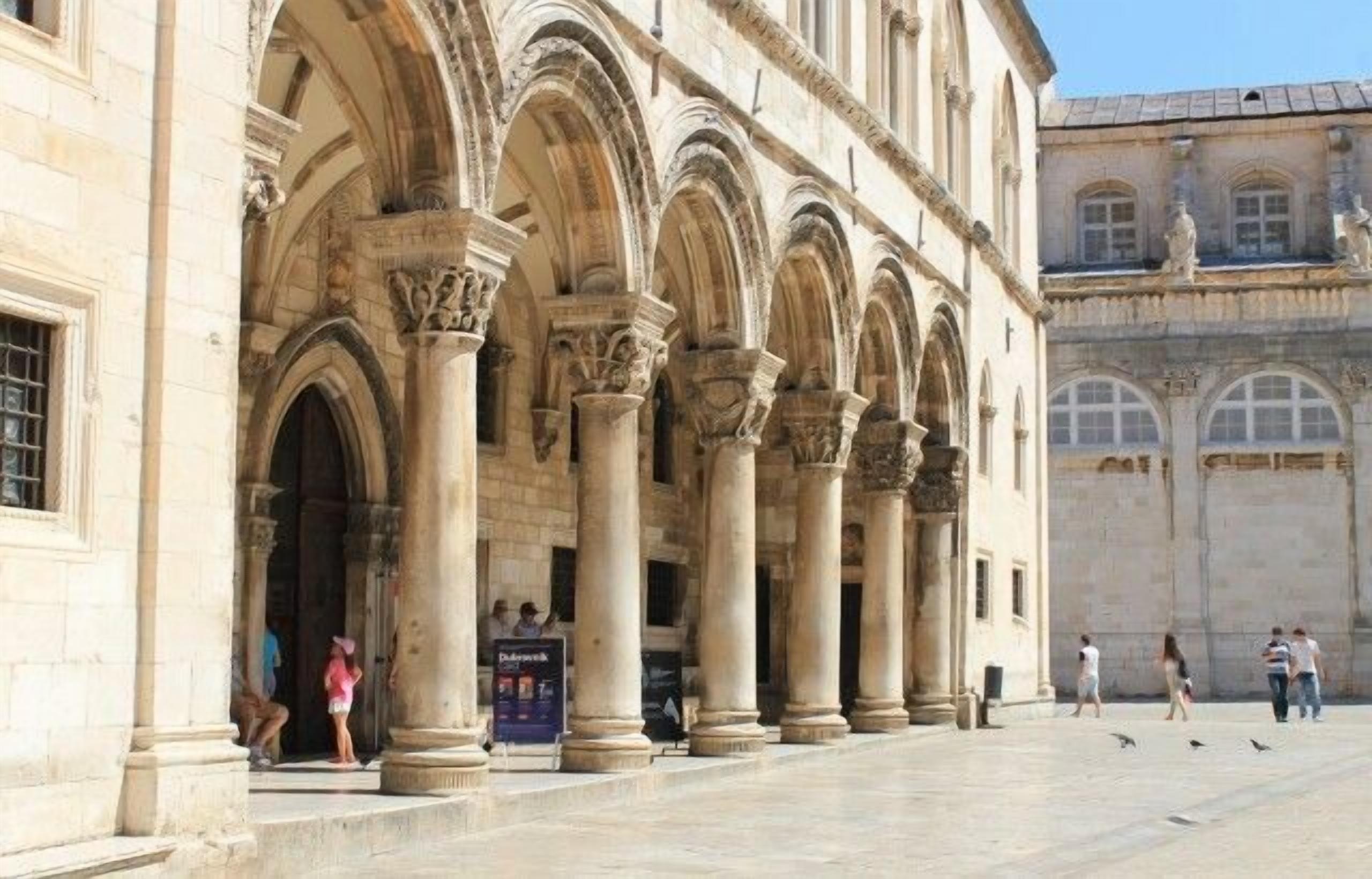 A historic building with a series of arches and columns, likely a public or cultural site.