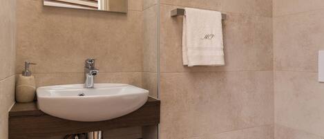Une salle de bain moderne avec un meuble-lavabo en bois, un évier, un miroir et des toilettes.