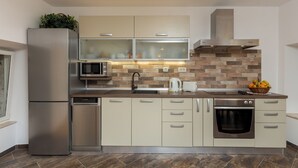 A modern kitchen with a stainless steel refrigerator, a microwave, a built-in oven, and a dishwasher.