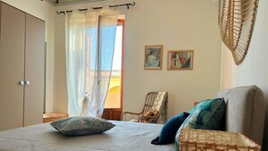 Une chambre à coucher avec un lit, une chaise et deux tableaux accrochés au mur.