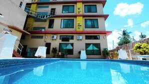 Un hotel con piscina, varios balcones y aire acondicionado.
