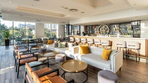 A modern bar area with seating and a bar counter. - Luxury Apartment Sandton / no Loadshedding / Dstv (Johannesburg)