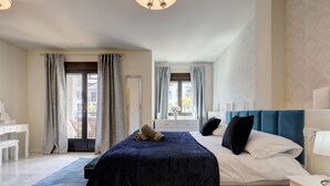 Un dormitorio con una cama grande, un escritorio y una ventana con cortinas.