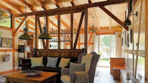 A rustic interior with exposed wooden beams, a sofa, a coffee table, and a bookshelf. - Holiday Home Farmhouse in Altes Forsthaus Boppard (Boppard)