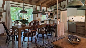 A rustic kitchen with wooden beams, a dining area with a wooden table and chairs, and a view of greenery outside. - Holiday Home Farmhouse in Altes Forsthaus Boppard (Boppard)