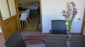 Un comedor con una mesa, sillas y un jarrón de flores.