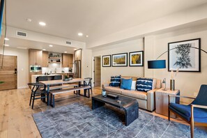 Un salon moderne comprenant un canapé, une table basse et un coin repas avec une table et des chaises.