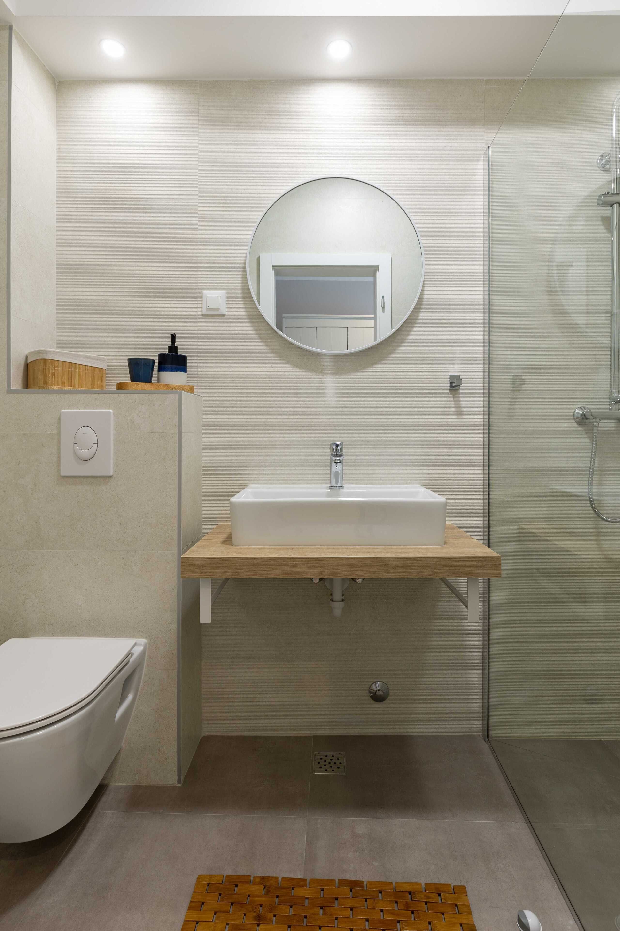 A modern bathroom with a toilet, sink, and shower.