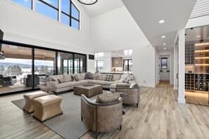 Un vaste espace de vie comprenant un grand canapé, des poufs et une table basse.
