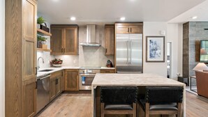Una cocina moderna con armarios de madera, electrodomésticos de acero inoxidable y encimera de mármol.