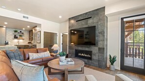 Una sala de estar moderna con chimenea, sofá de cuero y una mesa de centro.