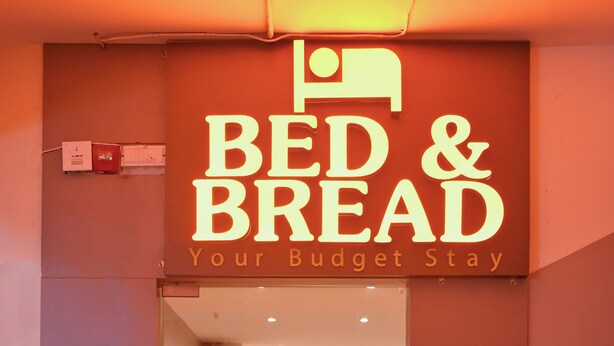 A hotel entrance with a sign reading "BED & BREAD Your Budget Stay". - Bed & Bread Dormitory (Bharuch)
