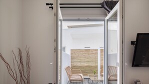 Un salon moderne doté d’une porte-fenêtre coulissante donnant sur un espace de détente extérieur.