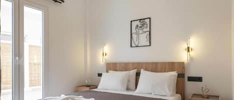 A modern bedroom with a large bed, two bedside tables, a wall-mounted artwork, and a ceiling light fixture.