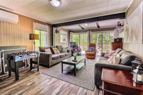 A spacious living room with a foosball table, sofas, and a coffee table. - Spa - Waterfront - Babyfoot | La Source (Saint-Côme)