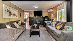 A living room with two sofas, a coffee table, a fireplace, and a television. - Spa - Waterfront - Babyfoot | La Source (Saint-Côme)