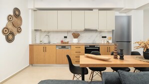 Una cocina moderna con armarios de madera, salpicadero de mármol y un refrigerador de acero inoxidable.