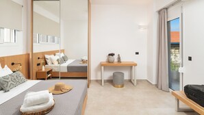 A modern hotel room with a bed, bedside table, and a view of the outdoors. - Elia City Apartments (Chania)