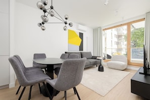 Ein modernes Wohnzimmer mit Essbereich, einer Couch und einem Fernseher.