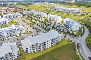 A modern residential complex with multiple apartment buildings, parking areas, and green spaces.