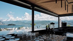 Un área de bar con vista a un lago y montañas.