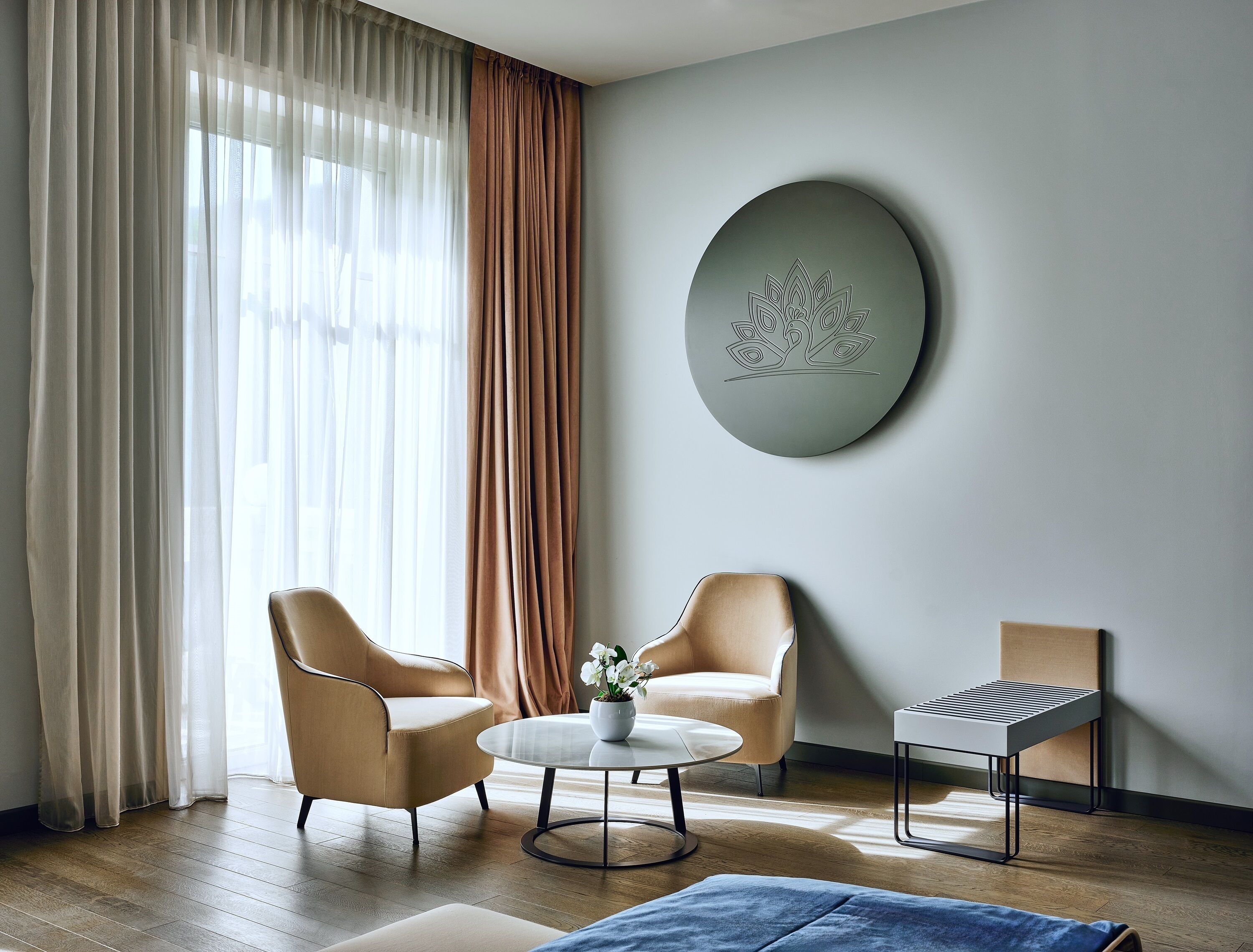 Una sala de estar moderna con dos sillones, una mesa de centro y una mesita auxiliar.