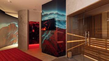 Een moderne hotelkamer met een groot bed, een aan de muur bevestigde televisie en een houten garderobe.