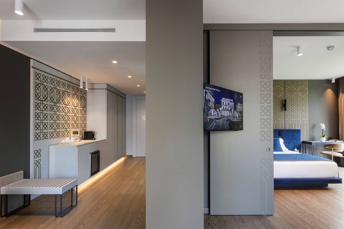 Une chambre d’hôtel moderne, équipée d’un lit, d’un bureau et offrant une vue sur la rue.