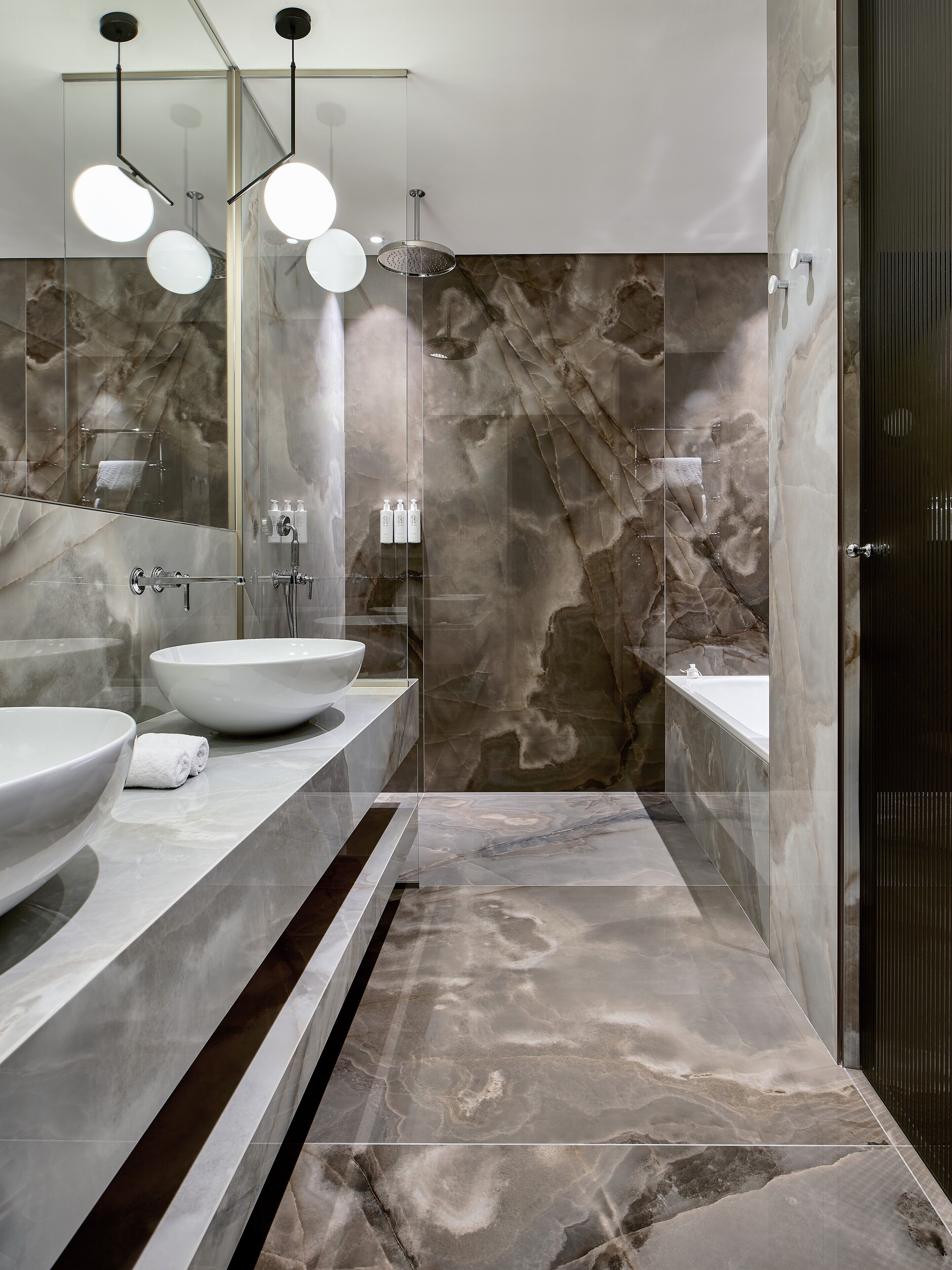 A modern bathroom with a large sink, a bathtub, and a glass-enclosed shower area.