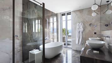 Ein modernes Badezimmer mit einer großzügigen, freistehenden Badewanne, einer gläsernen Dusche und einem Waschtisch mit zwei Becken.