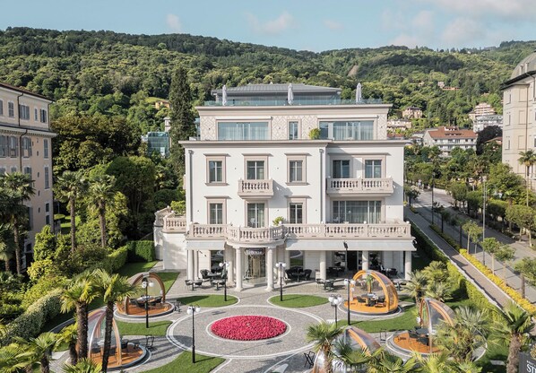 Un hotel de varios pisos con un patio central, asientos al aire libre y un jardín ajardinado.