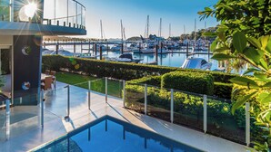 A modern outdoor pool area with a view of a marina and boats. - Pavillions 6, Pavilions 6 on Hamilton Island (Hamilton Island)
